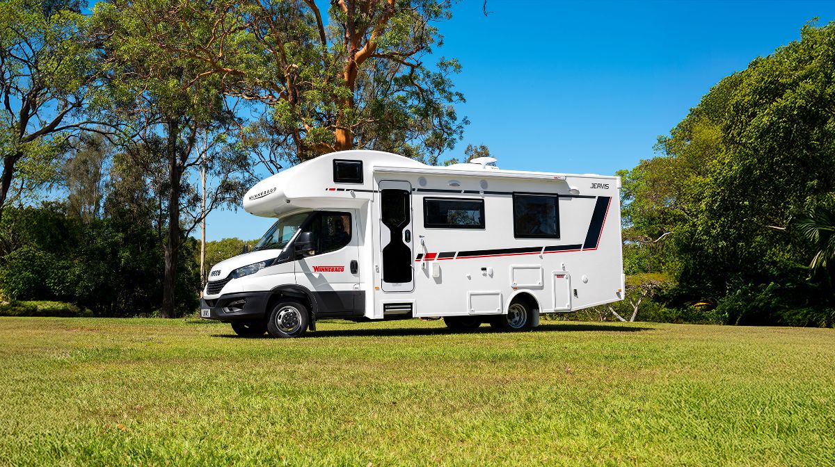 Couple relaxing beside their campervan